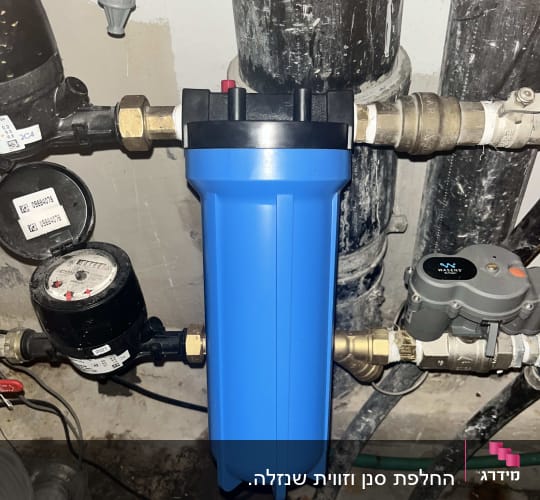 מסנן מים כחול וצינורות במערכת אינסטלציה